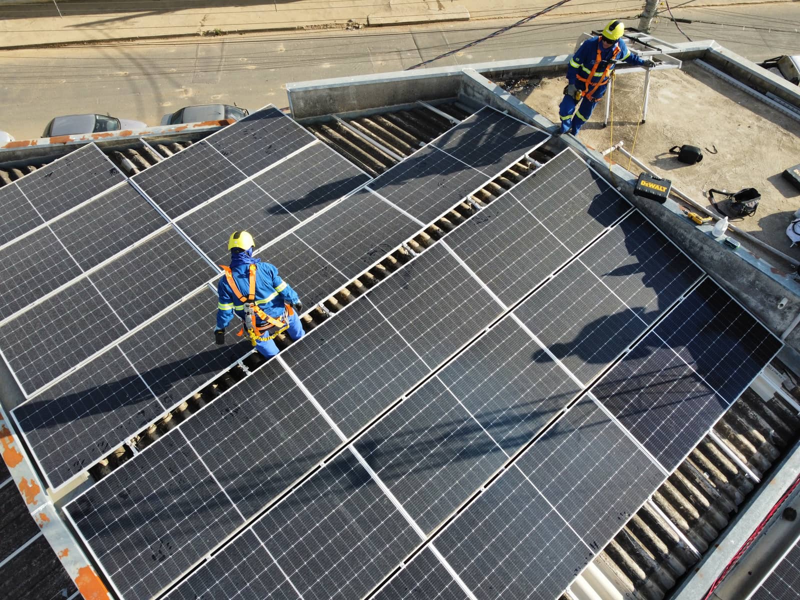Equipe realizando instalação de painéis solares em telhado
